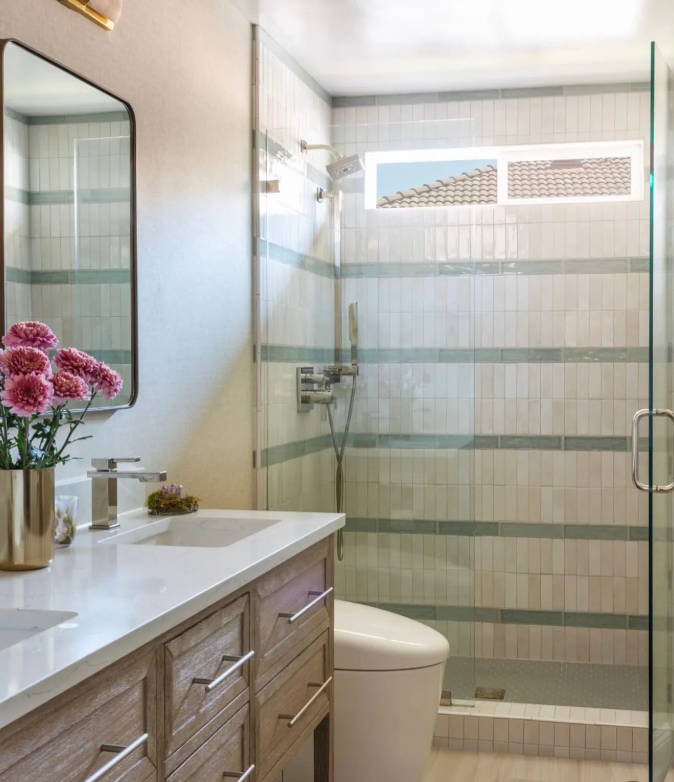 Guest bathroom with a striped tile shower surround, quartz counter and white oak vanity