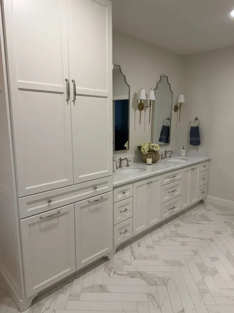 Primary bathroom vanity wall with a floor-to-ceiling storage tower and arched mirrors
