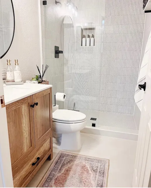 Guest bathroom with a white oak vanity and fluted tile shower surround
