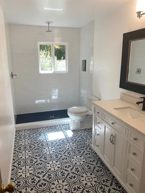 Bathroom remodel with patterned cement tile flooring and a curbless walk-in shower