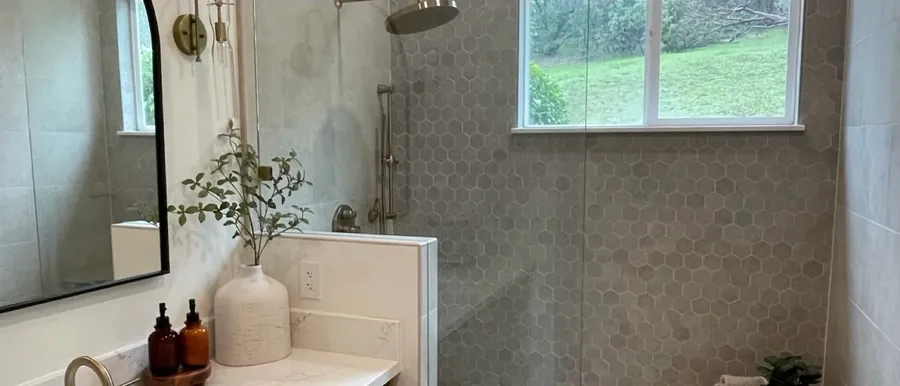 The same bathroom after remodel: a large-format tile walk-in shower, quartz vanity and modern fixtures