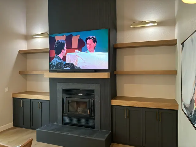 Custom fireplace surround with floating white oak shelves and built-in base cabinetry