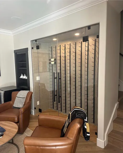Glass-enclosed wine storage with metal peg racking built into a living room wall