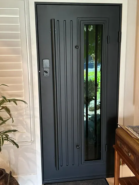 Modern black steel front entry door with a full-height glass sidelight