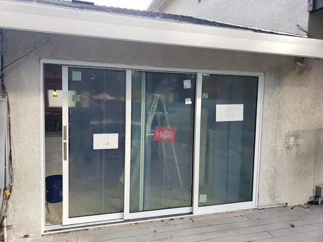New multi-slide glass patio door installed in a stucco exterior wall during construction