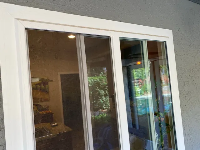Newly installed sliding glass patio door with fresh interior trim and casing