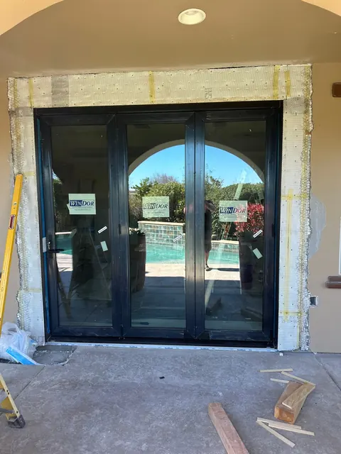 Multi-panel patio door installed during construction, framed to a poolside patio