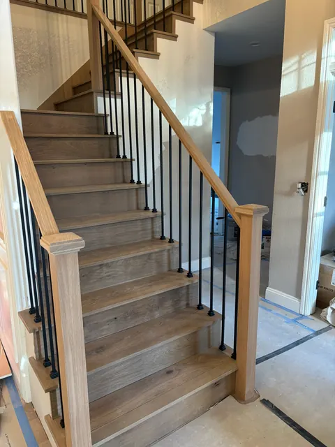 Remodeled staircase with white oak treads and slim iron balusters