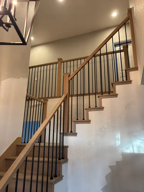 Staircase remodel with a white oak handrail and iron baluster infill