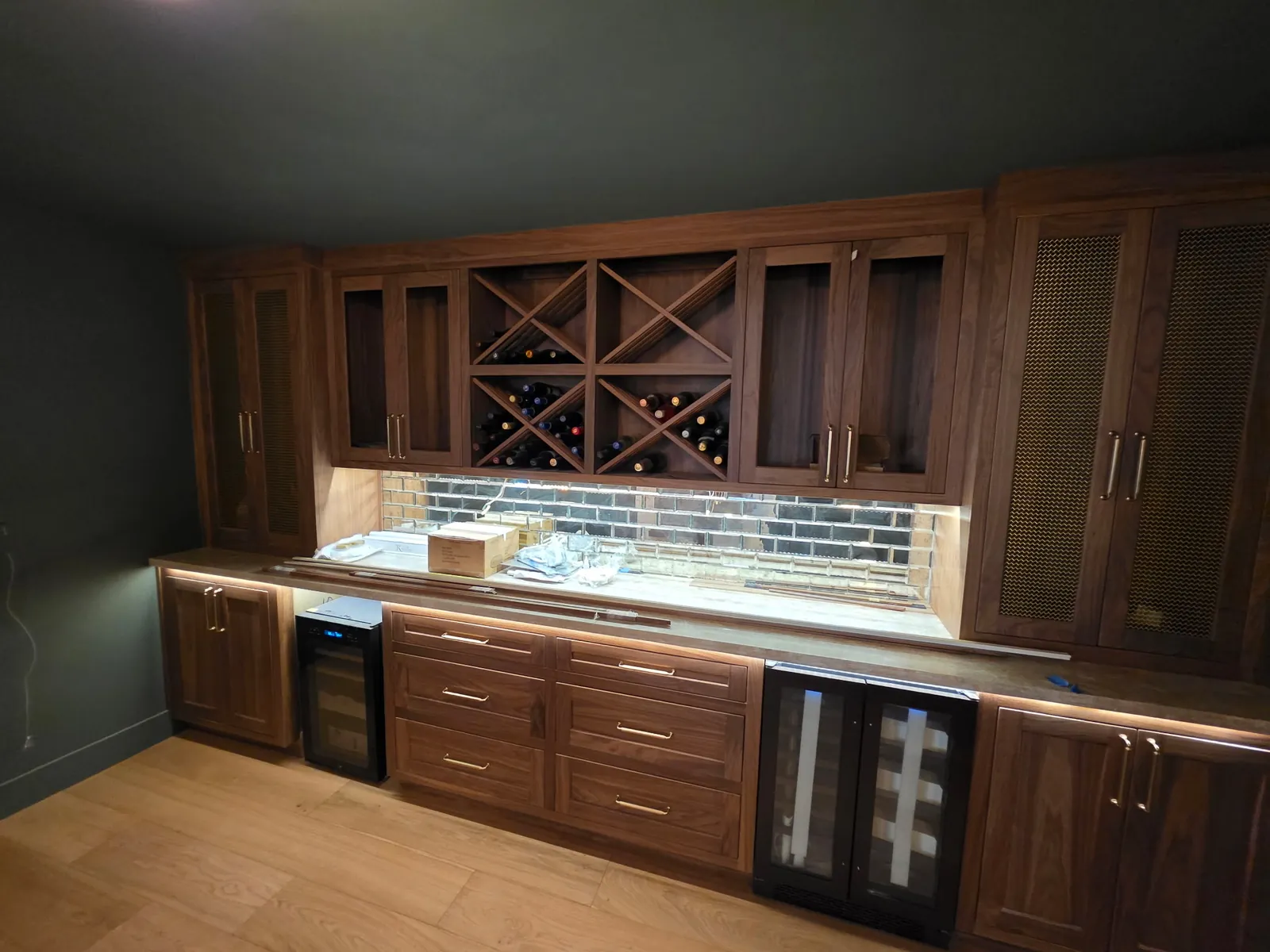 Custom walnut wet bar with lattice wine storage and built-in beverage refrigerators