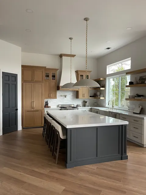 Custom kitchen with rift-sawn oak cabinetry, a charcoal island and plaster range hood