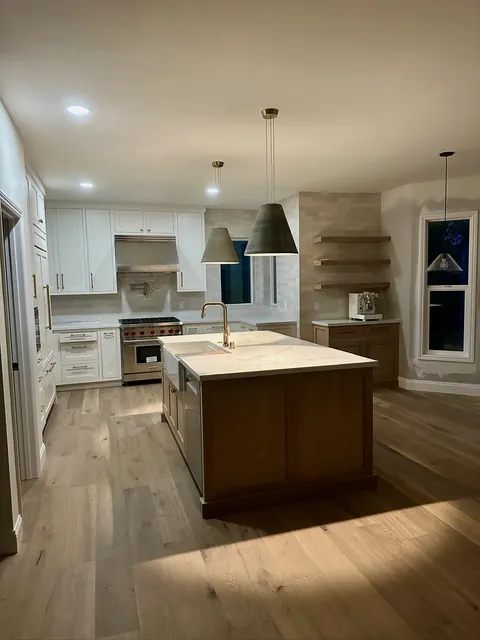 Kitchen remodel with a walnut island, white perimeter cabinetry and white oak plank flooring