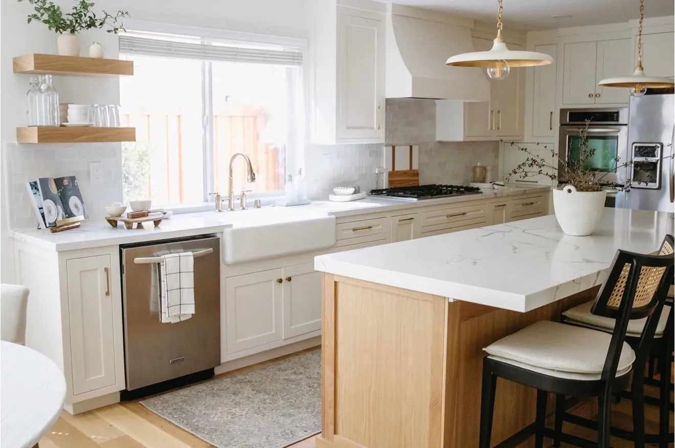 White kitchen with a white oak island, farmhouse apron sink and quartz countertops