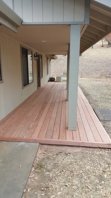 Covered porch with a new redwood deck running the length of the house