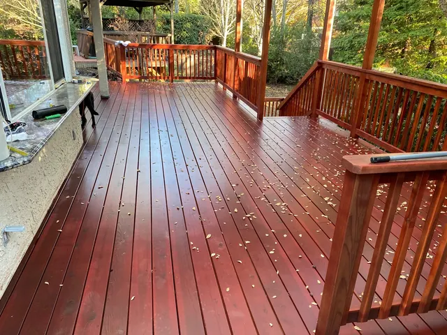 Large redwood deck with freshly applied stain and a matching wood railing