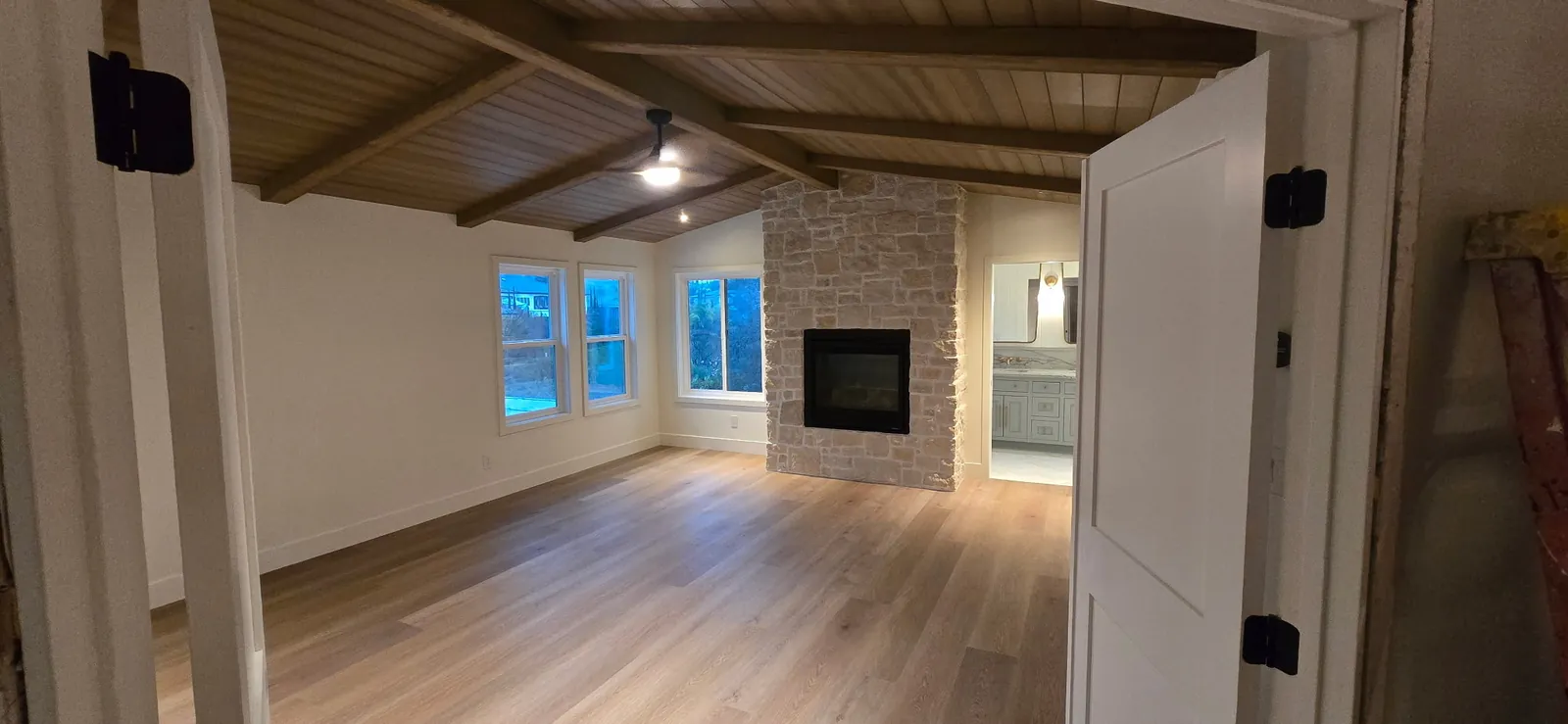Whole house remodel with a vaulted wood plank ceiling, brick fireplace and new white oak flooring